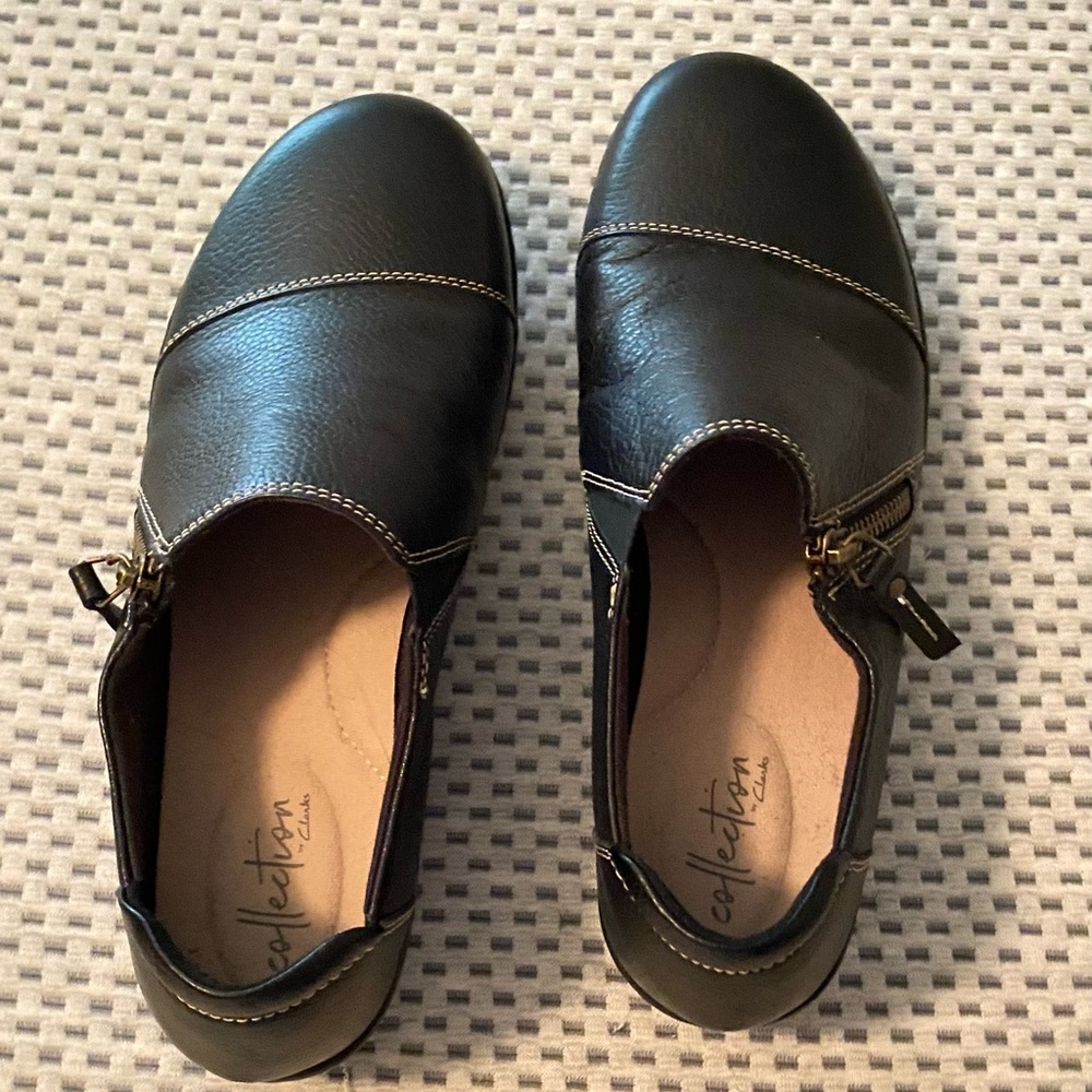 NWOT!! Clark’s size 7.5 black slippers with zippers and elastic closure.